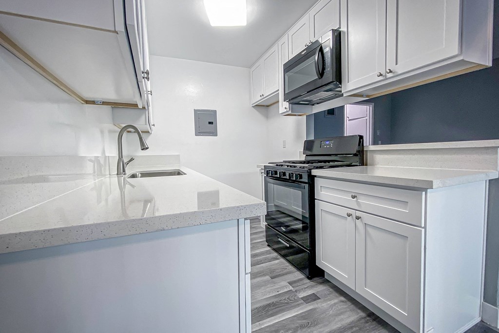 a kitchen with white cabinets and a stove and a microwave
