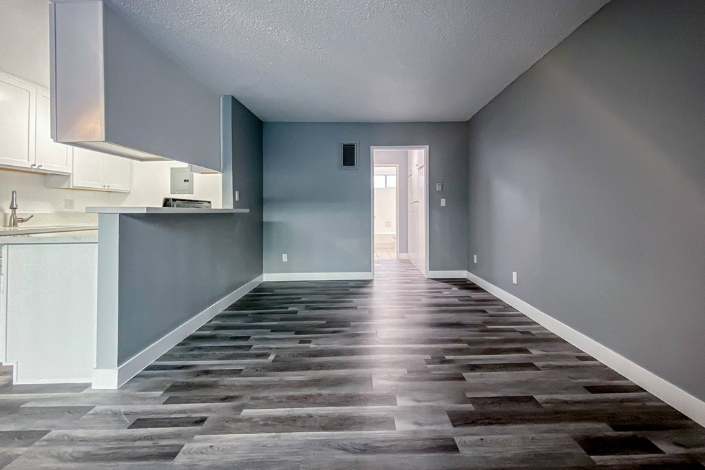 a renovated kitchen with a wood floor and blue walls