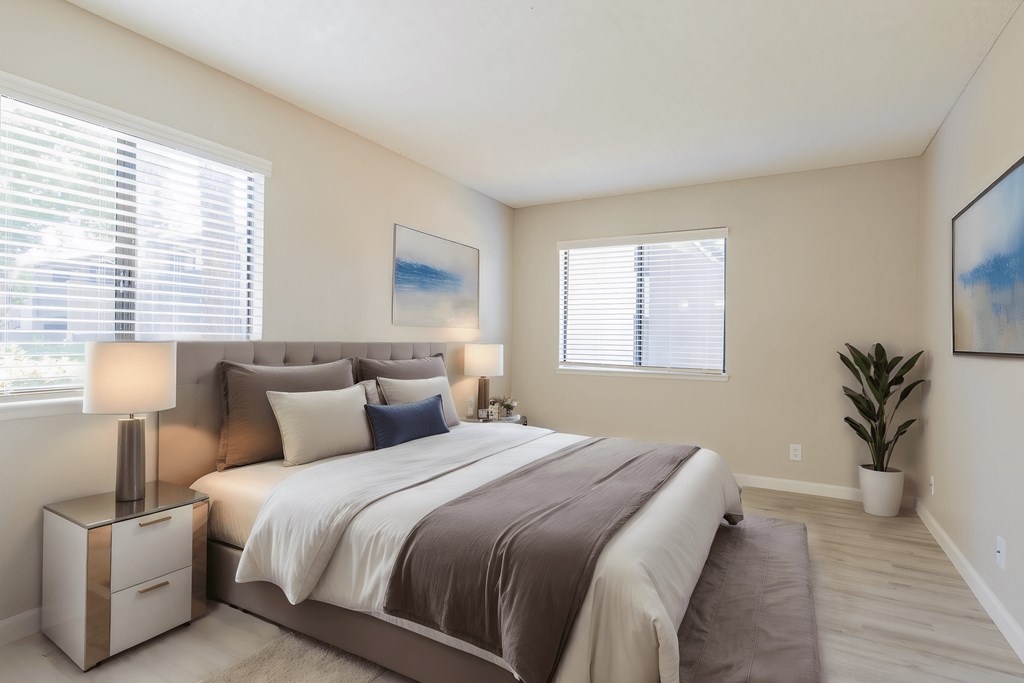 a bedroom with a bed and two windows