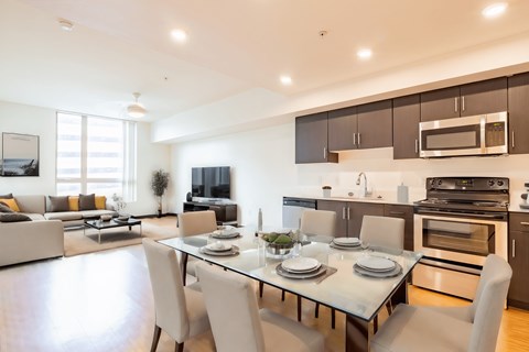 a living room with a table and chairs and a kitchen