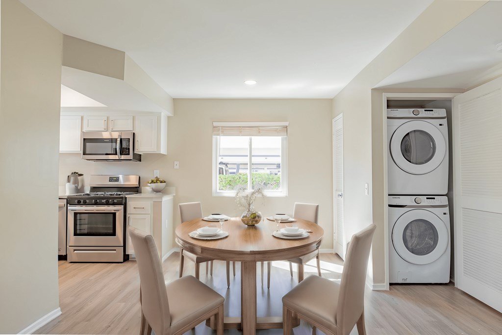 a living room with a table and chairs and a washing machine and a washer