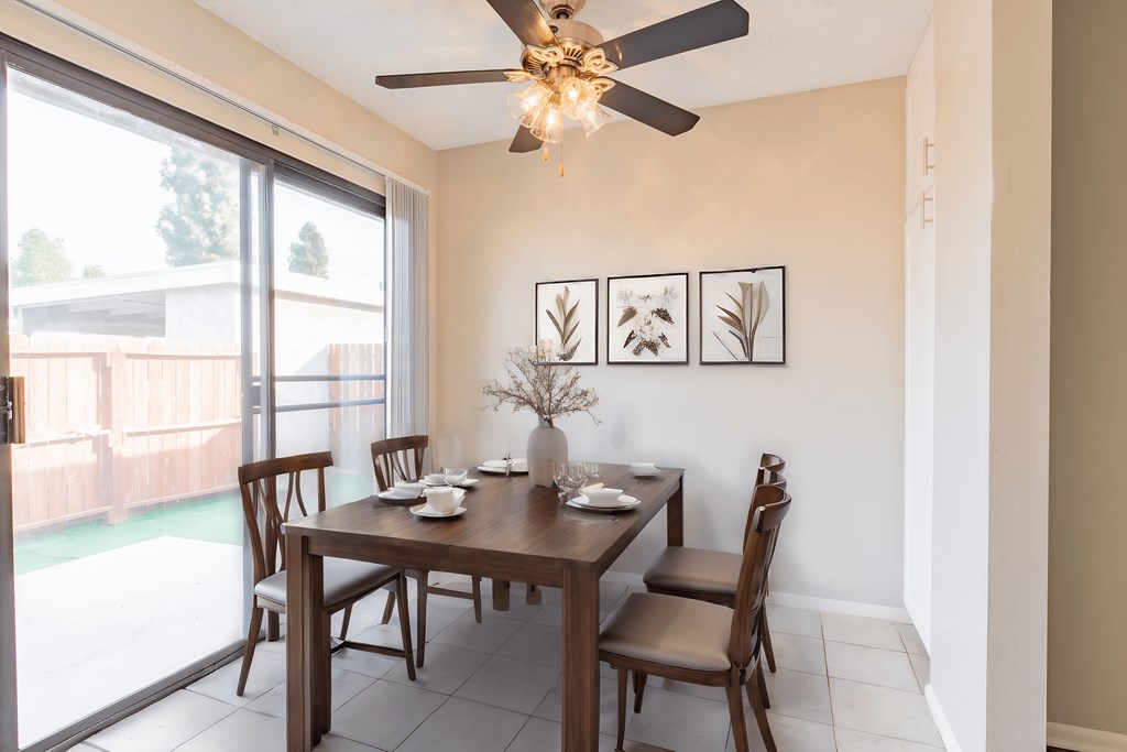 a dining room with a table and chairs and a ceiling fan