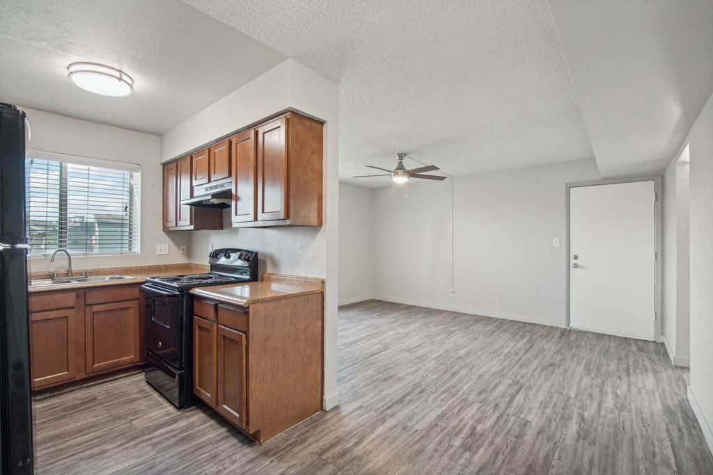 an empty kitchen and living room with a ceiling fan