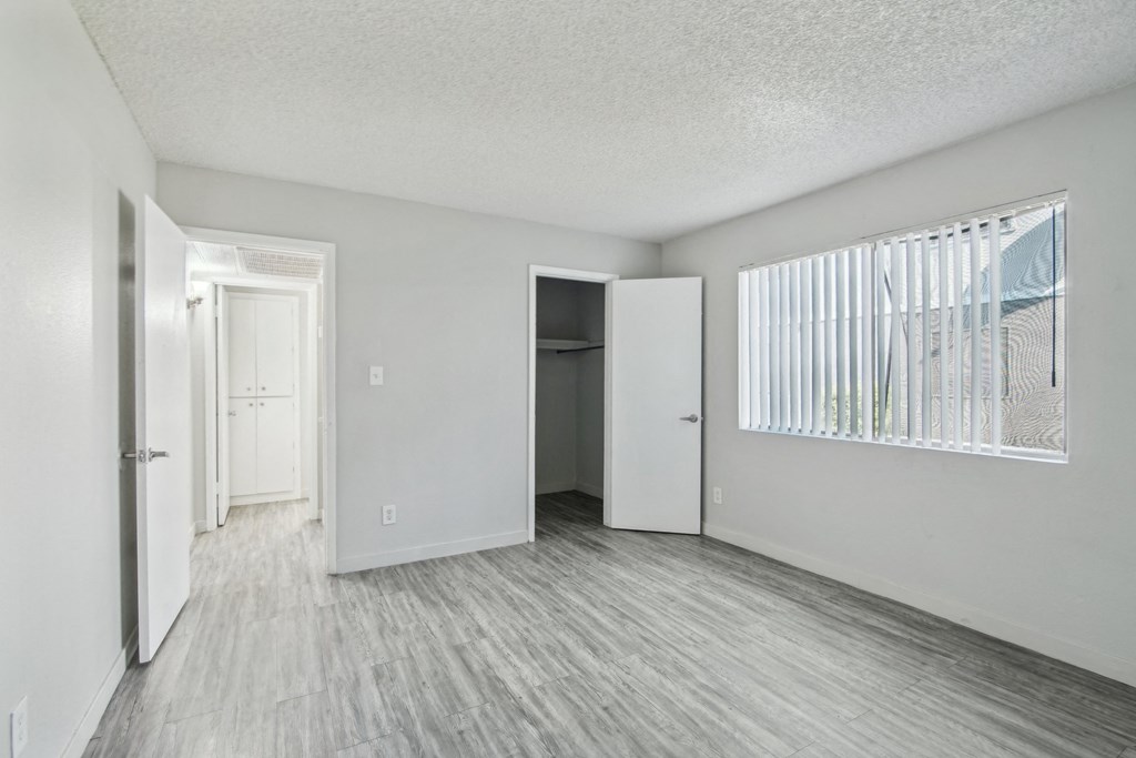 an empty living room with white walls and wood flooring