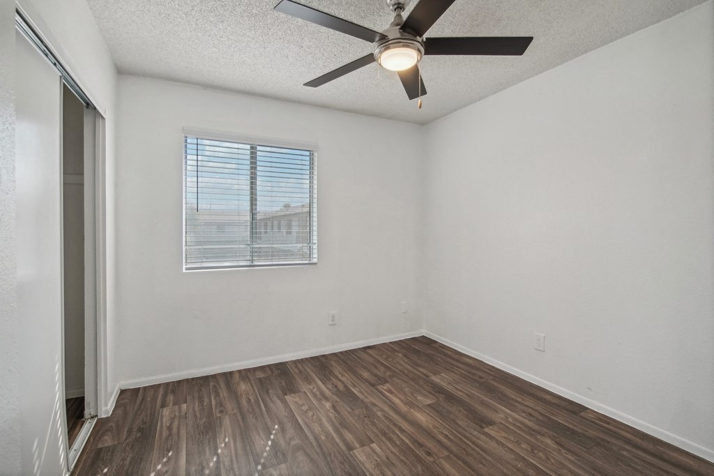 the living room of our studio apartment atrium with a ceiling fan and a window