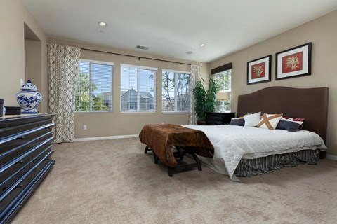 A bedroom with a large bed and a dresser.