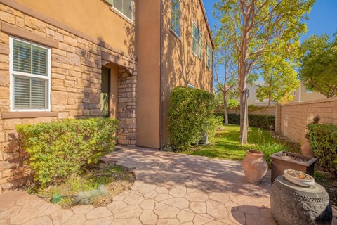 a backyard with a stone building and vases on the ground