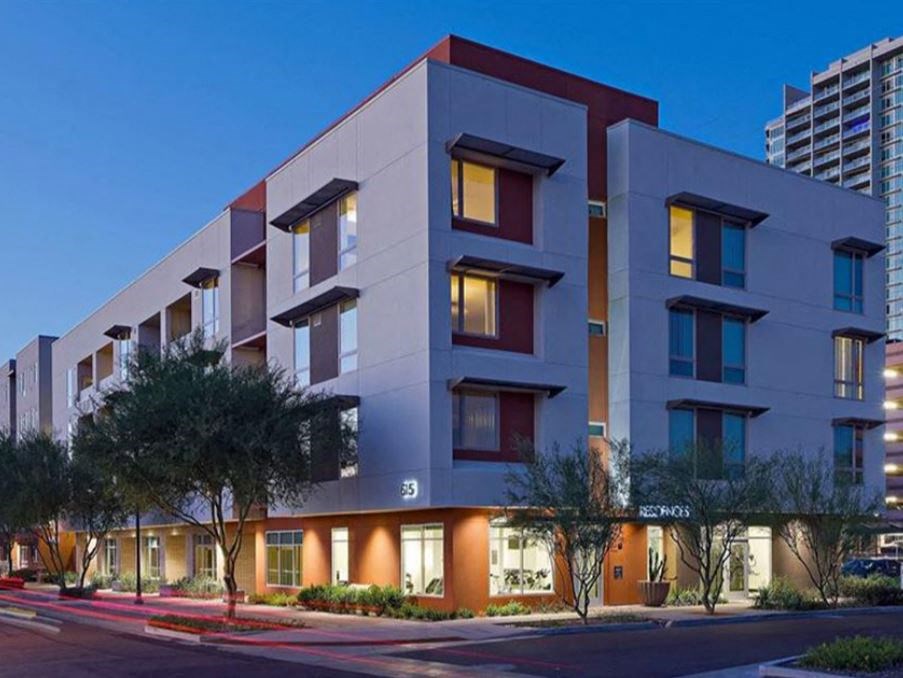 an apartment building on a city street at dusk