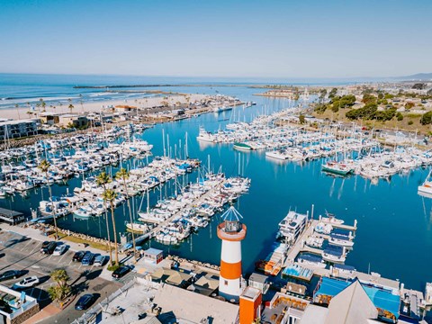 a view of the marina with many boats and a lighthouse