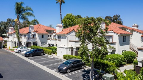 a row of houses with cars parked in a parking lot