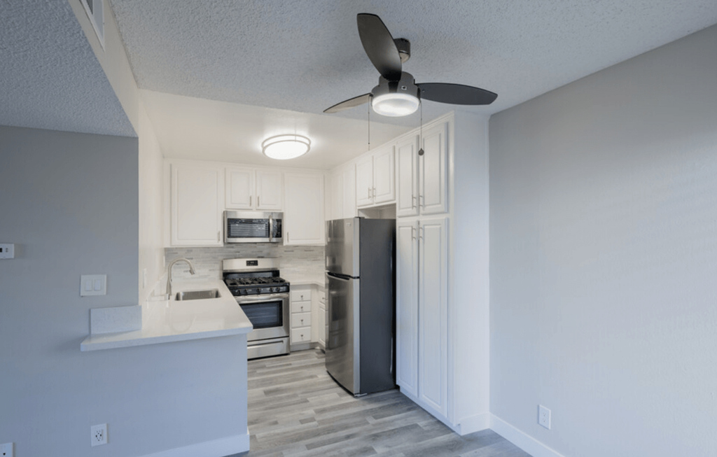 a kitchen with a refrigerator freezer and a stove top oven