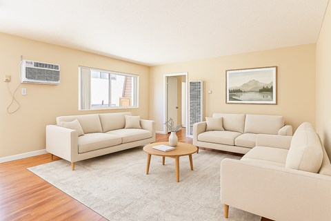 A living room with two couches, a coffee table, and a painting on the wall.