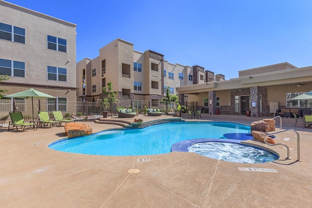 a large swimming pool in front of an apartment building