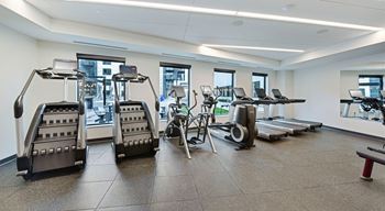 A gym with treadmills, elliptical machines, and other exercise equipment.