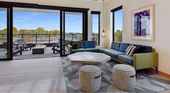 A living room with a blue couch and a large window.