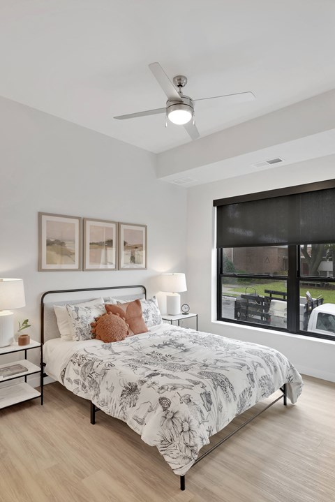A bedroom with a large bed and a ceiling fan.
