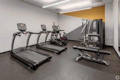 a gym with cardio equipment and weights in a building