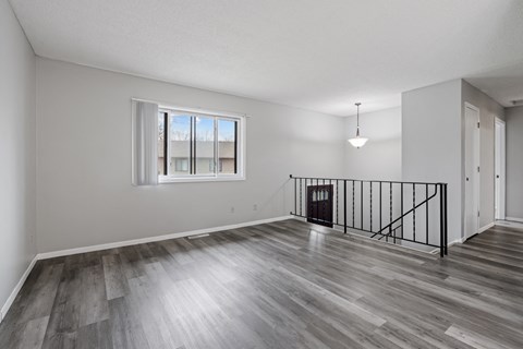 an empty living room with hardwood floors and a window