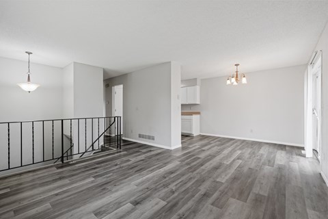 the living room and dining room of an apartment with wood flooring