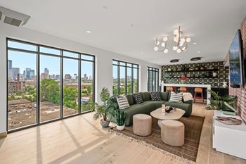 A living room with a green couch and a view of the city.