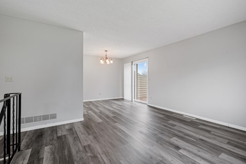 a living room with white walls and a sliding glass door