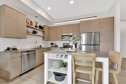 A modern kitchen with wooden cabinets and stainless steel appliances.
