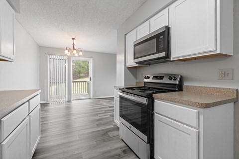 the kitchen of our studio apartment atrium with white cabinets and black appliances