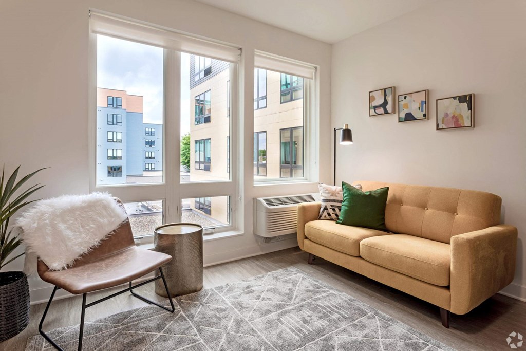 a living room with large windows and a couch and a chair