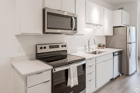 a kitchen with white cabinets and stainless steel appliances and a microwave