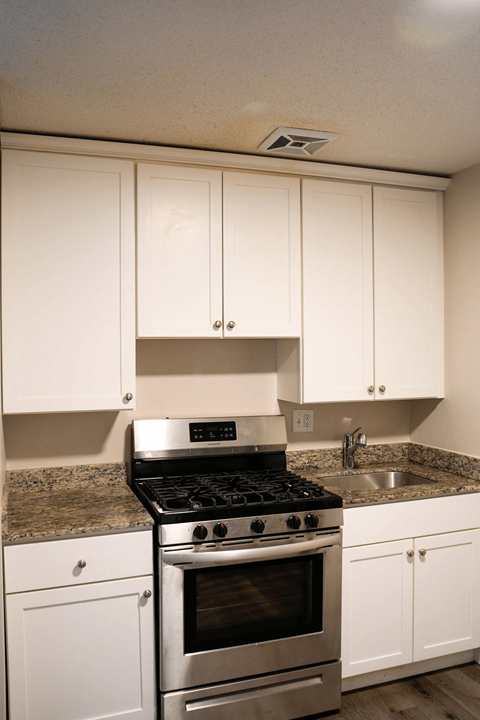 A kitchen with a stove and cabinets.