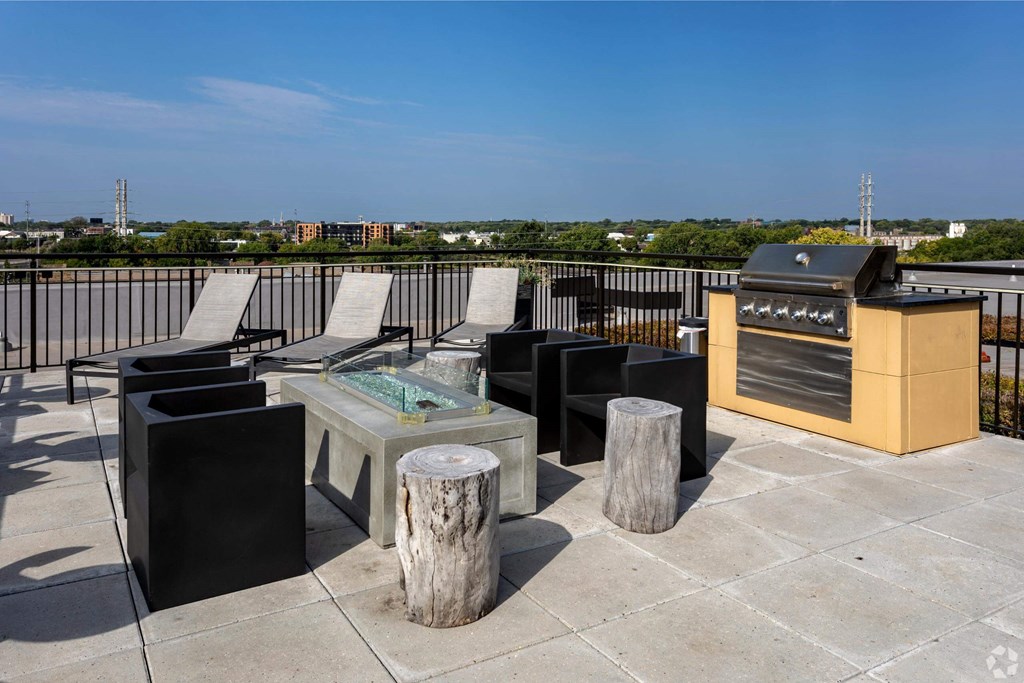 the outdoor patio has a grill and a table with chairs on it