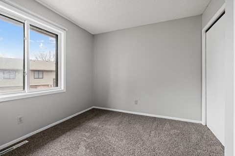 an empty room with carpet and a window