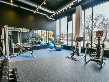 a gym with exercise equipment and large windows
