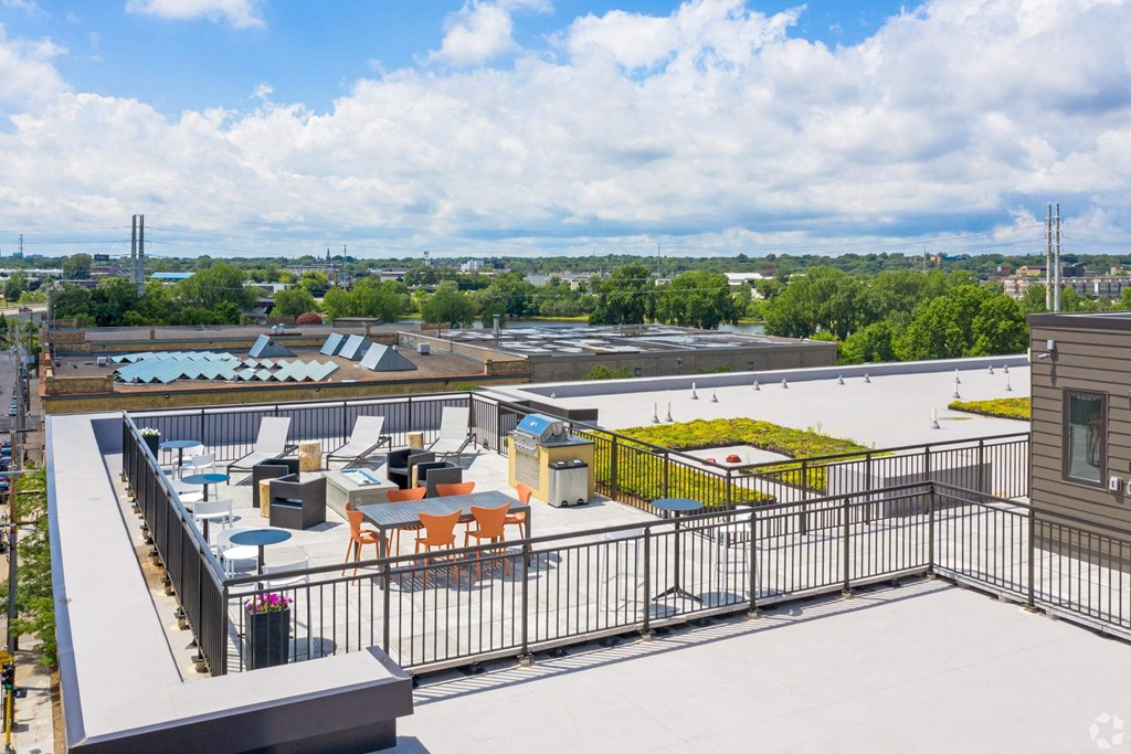 the terrace of a building with tables and chairs on top of a roof
