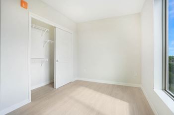 an empty room with a closet and a window