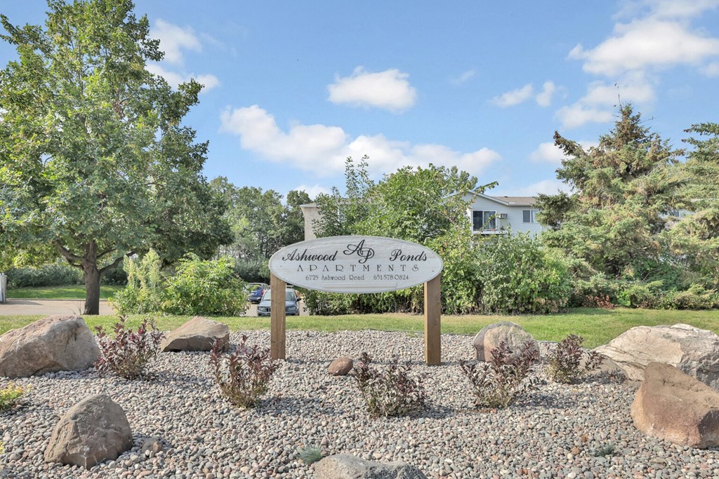 A sign that says "Shadow Ponds" stands in front of a house.