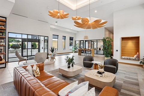 A modern living room with a brown leather sofa and a large chandelier.