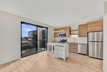 A modern kitchen with a white table and a refrigerator.