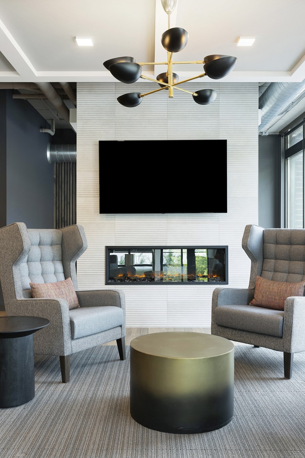 a living room with two chairs and a television on the wall