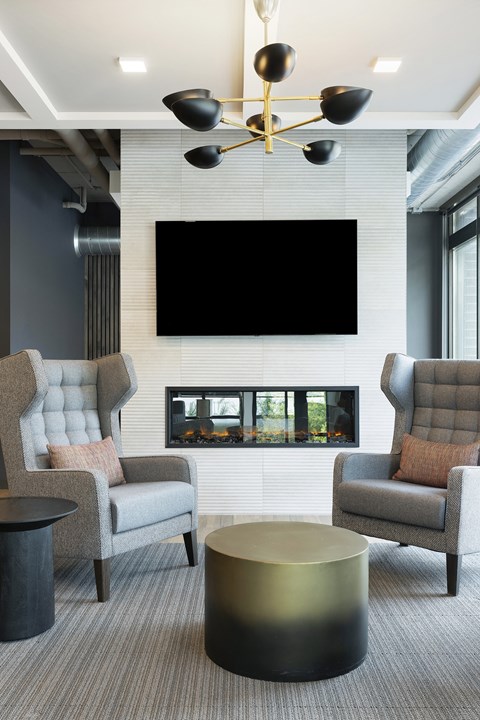 a living room with two chairs and a television on the wall