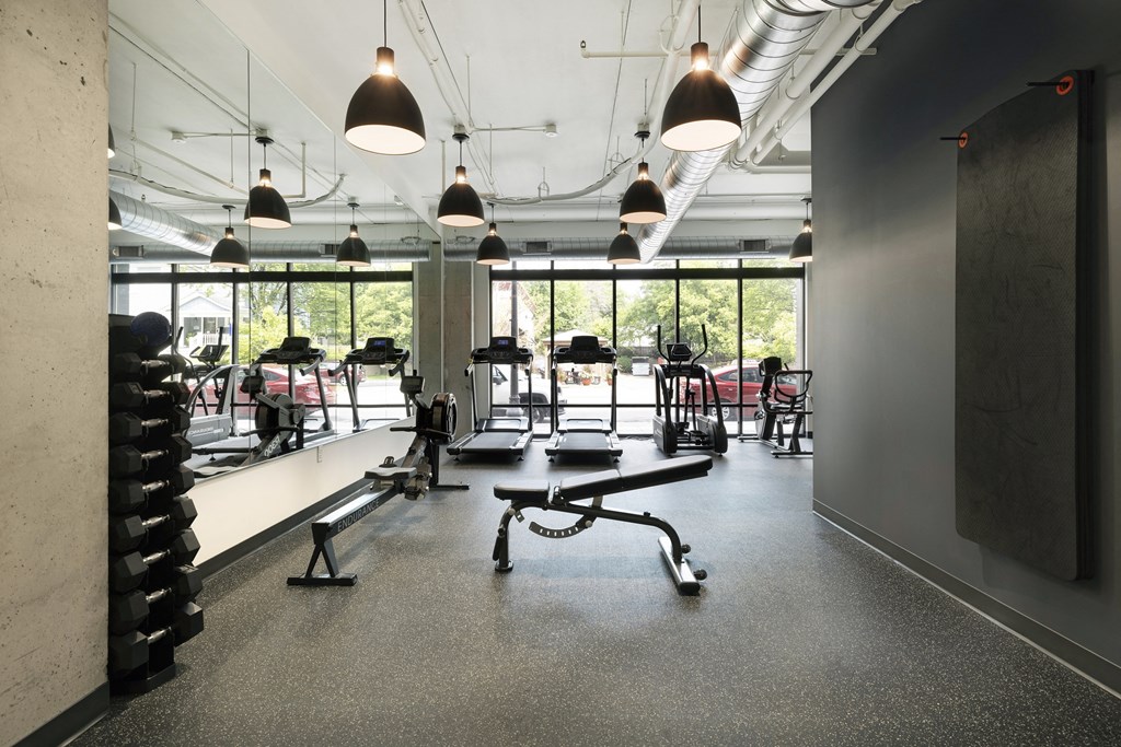 a gym with weights machines and a window
