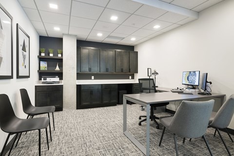 an office space with a desk and chairs and a computer