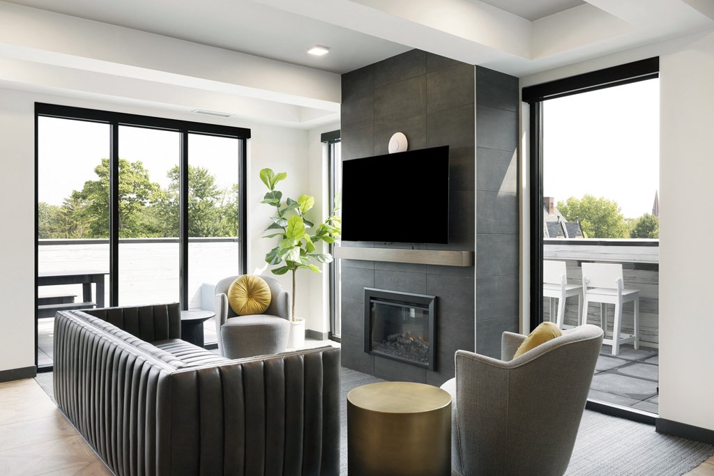 a living room with a fireplace and chairs and a television