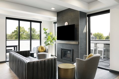 a living room with a fireplace and chairs and a television