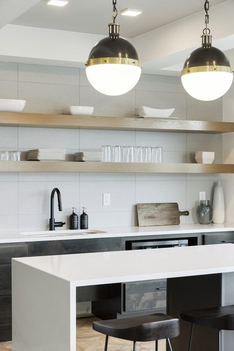 a kitchen with white cabinets and stainless steel appliances and lights
