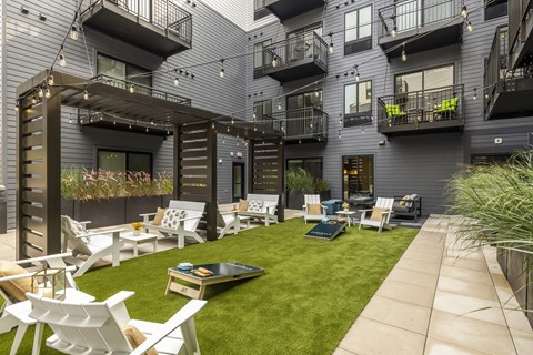 a courtyard with chairs and tables and grass