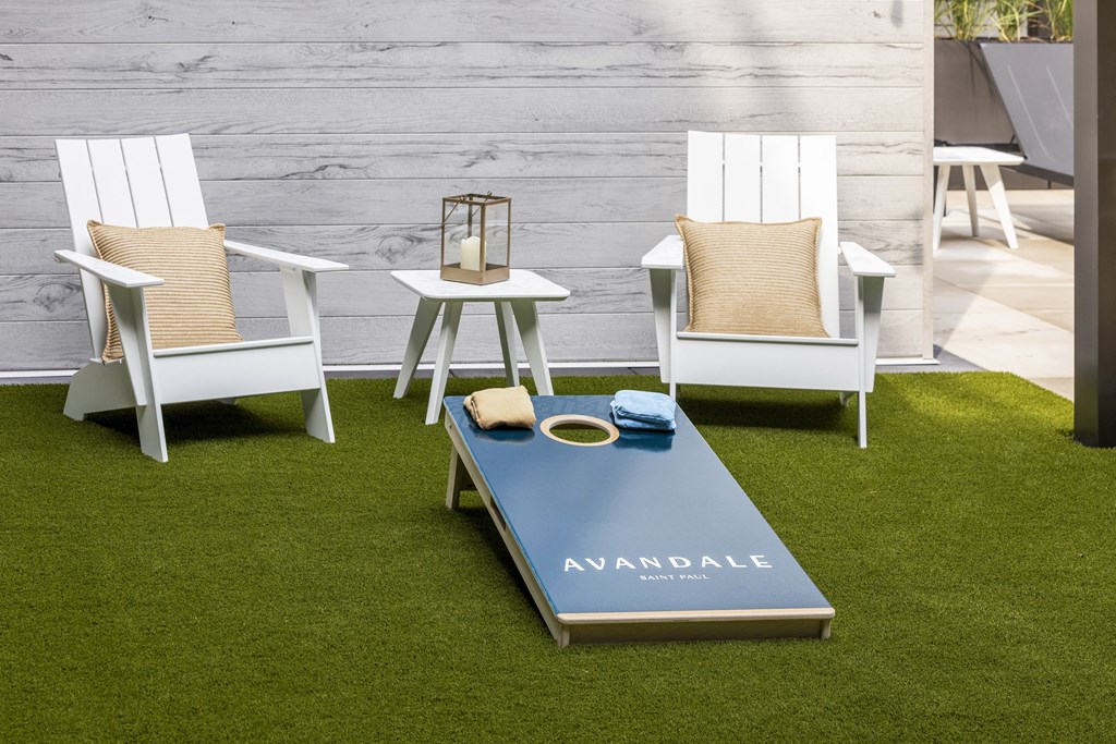 a group of white chairs around a coffee table on the grass