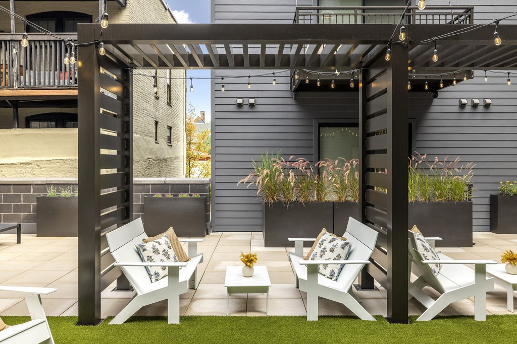 a group of white lounge chairs and tables on a patio