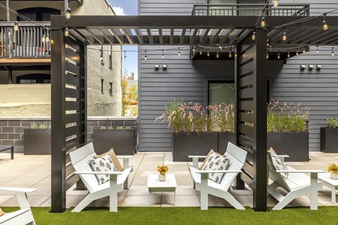 a group of white lounge chairs and tables on a patio