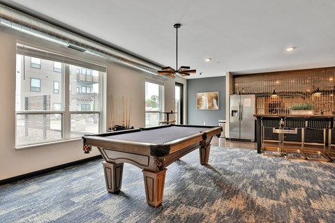 A pool table in a room with a ceiling fan.